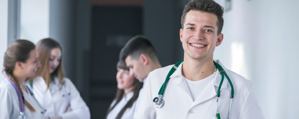 Happy businessman giving a presentation to group of colleagues a Young happy entrepreneur leading a seminar to group of healthcare workers and business people in convention center.